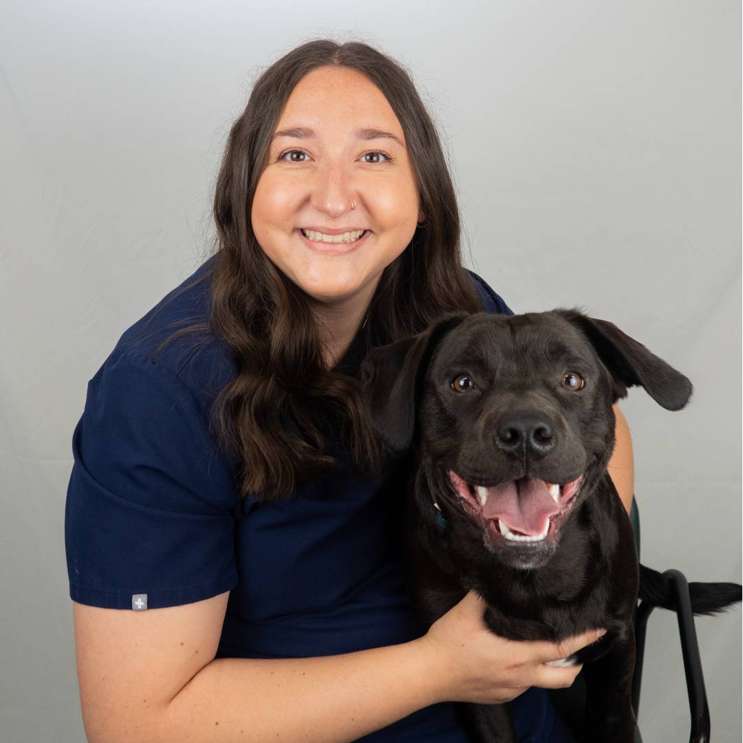 Jacie smiling holding black dog