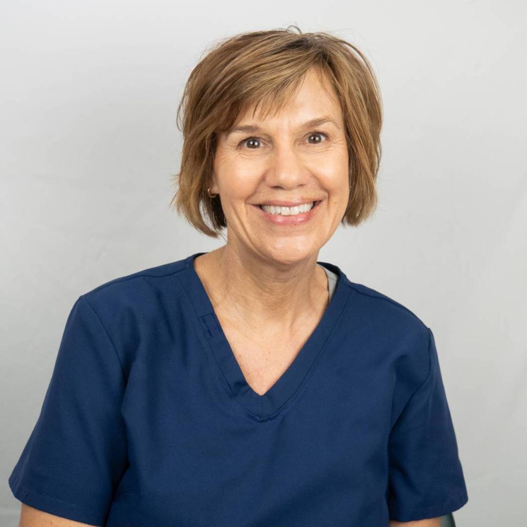 Nancy in blue scrubs smiling